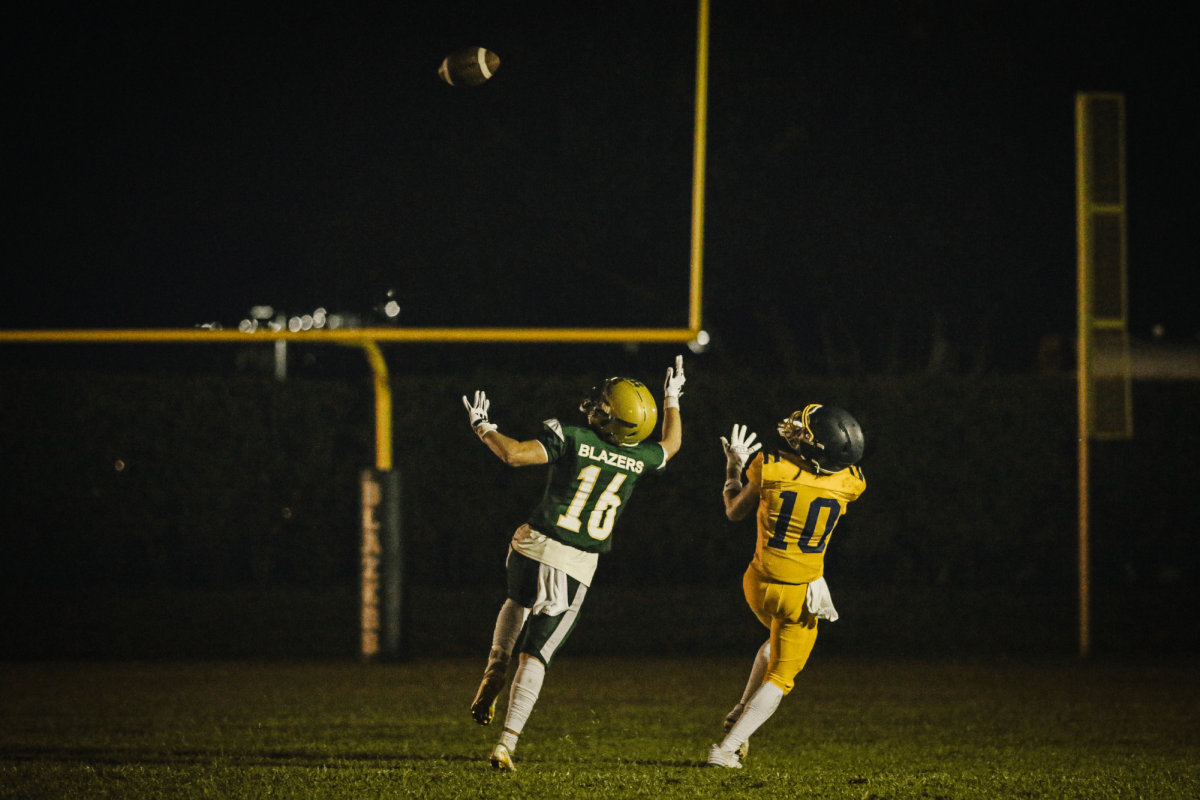 Junior wide receiver Joshua Harelik extends for the pass while the Boca Christian player attempts to block and intercept the ball toward the end of the second quarter on September 27, 2024. The team won 31-14.